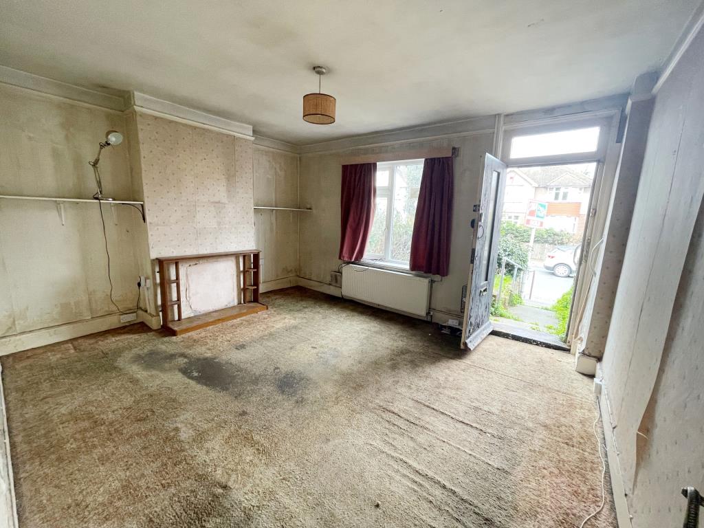 Lot: 1 - THREE-BEDROOM TERRACE HOUSE FOR REFURBISHMENT - Living room with view out to road